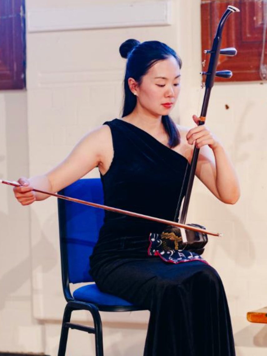 A Chinese musician playing on a traditional Erhu, Chinese musical instrument