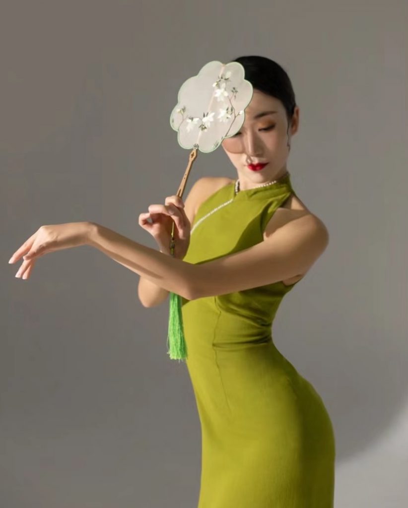 A Chinese performer holding a traditional circular fan